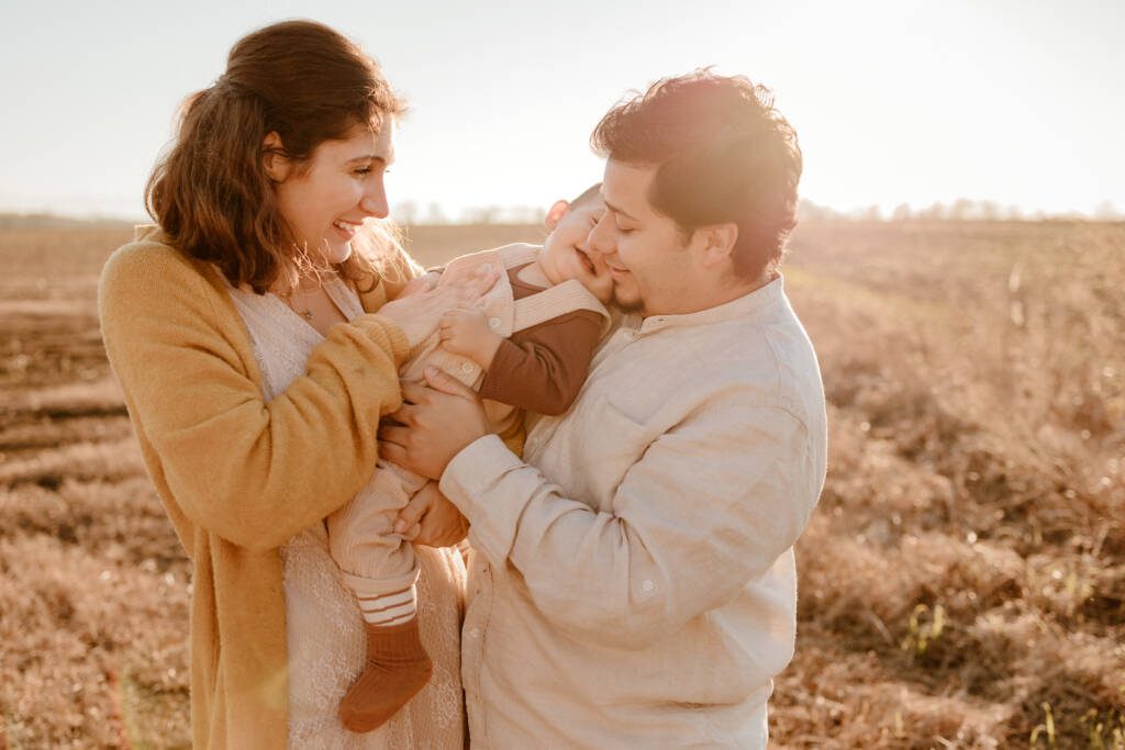 Une famille avec un bébé photographiés au coucher du soleil par Marine Delforge photographe à Pau