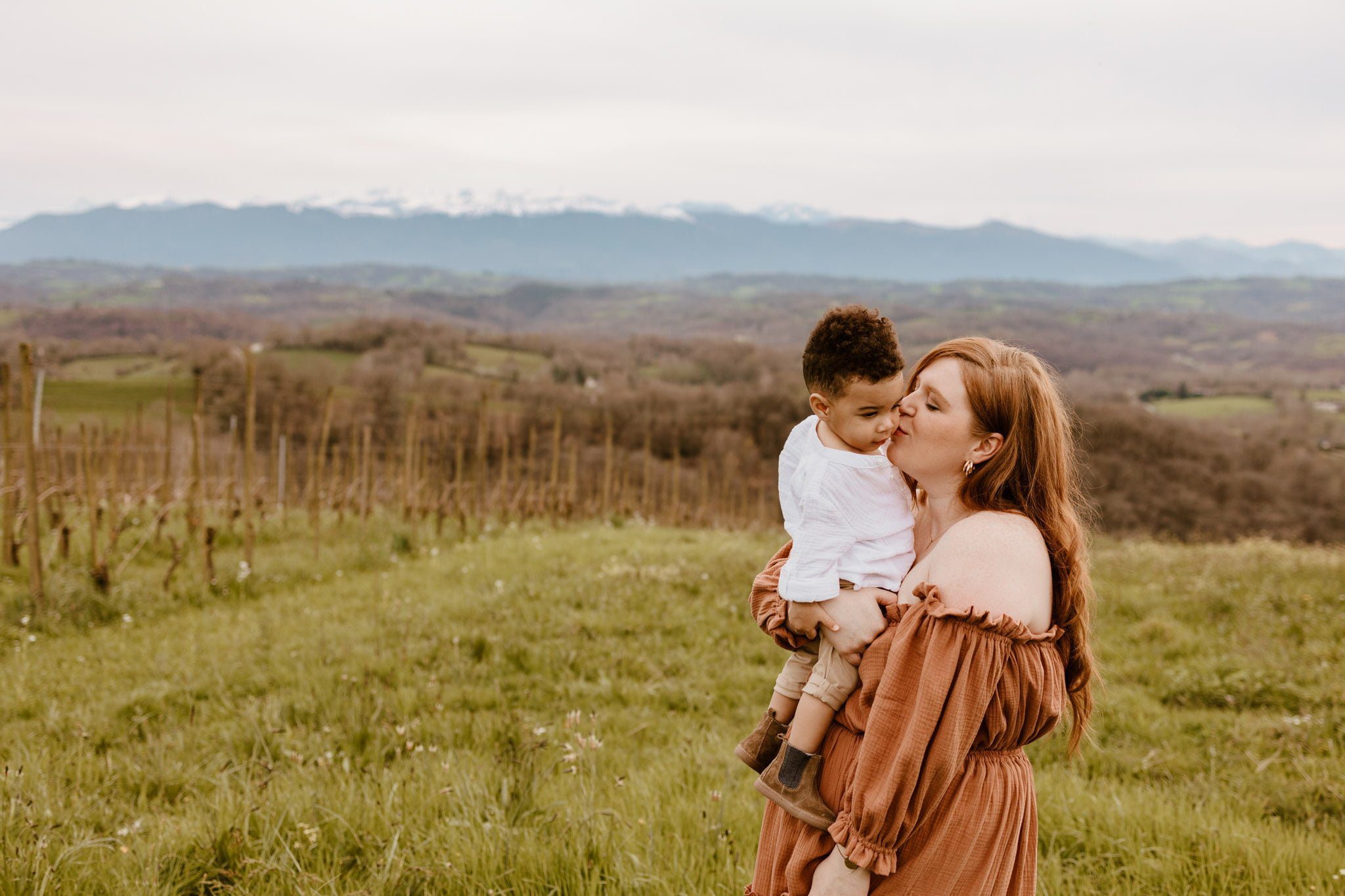maman qui embrasse son bébé face aux pyrénées