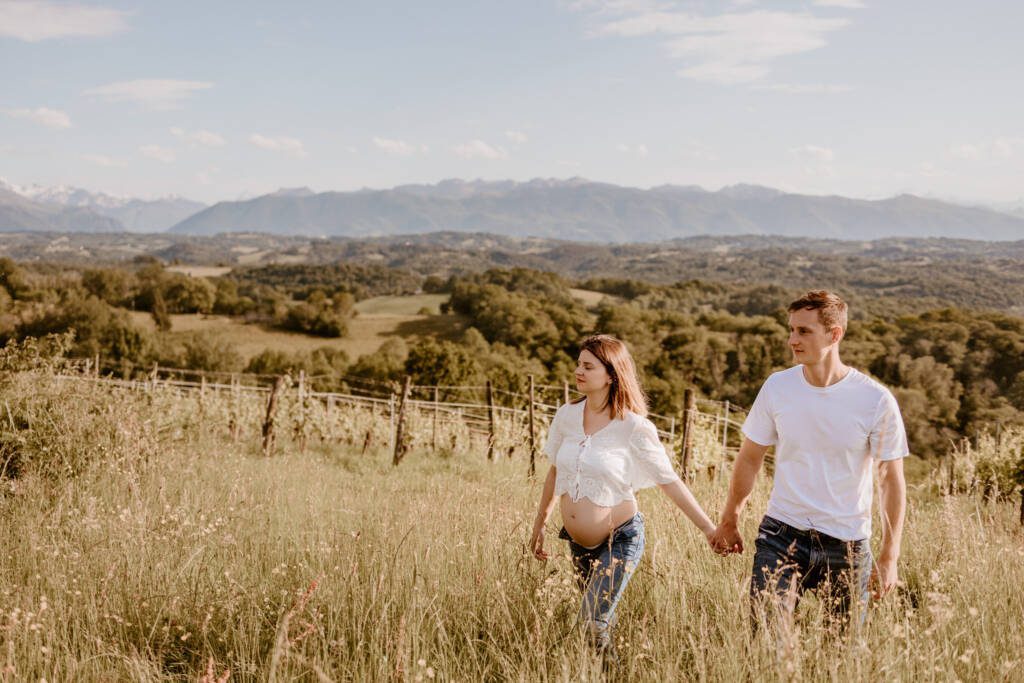 Un couple de futurs parents photographiés par Marine Delforge photographe à Pau avec les Pyrénées en fond