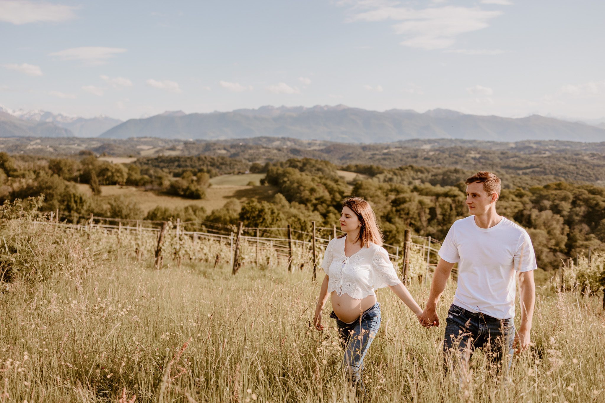 Un couple de futurs parents photographiés par Marine Delforge photographe à Pau avec les Pyrénées en fond