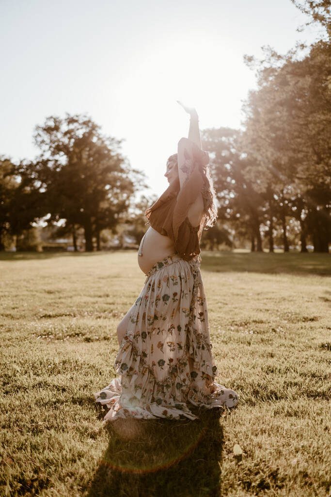 femme enceinte portant une jolie jupe fleurie au coucher du soleil. Photo par Marine Delforge photographe à Pau.