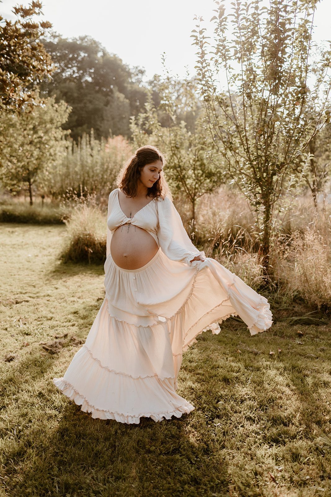 future maman faisant tournoyer sa magnifique robe de grossesse en mousseline de coton. Photo par Marine Delforge - Photographe à Pau et dans le Béarn